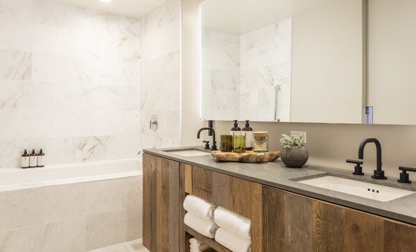 Une salle de bain moderne avec un meuble-lavabo en bois, deux vasques, un grand miroir et une baignoire.