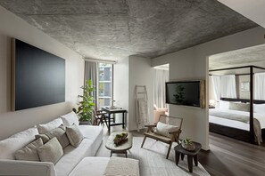 Una sala de estar moderna con un televisor de pantalla plana grande, un sofá, una mesa de centro y una escalera apoyada en la pared.
