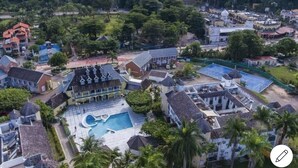 An aerial view of a resort with multiple buildings, a swimming pool, and surrounding greenery. - Cool's 1bd, Villa B6, On the Beach&Garden View WIFI (Ocho Rios)