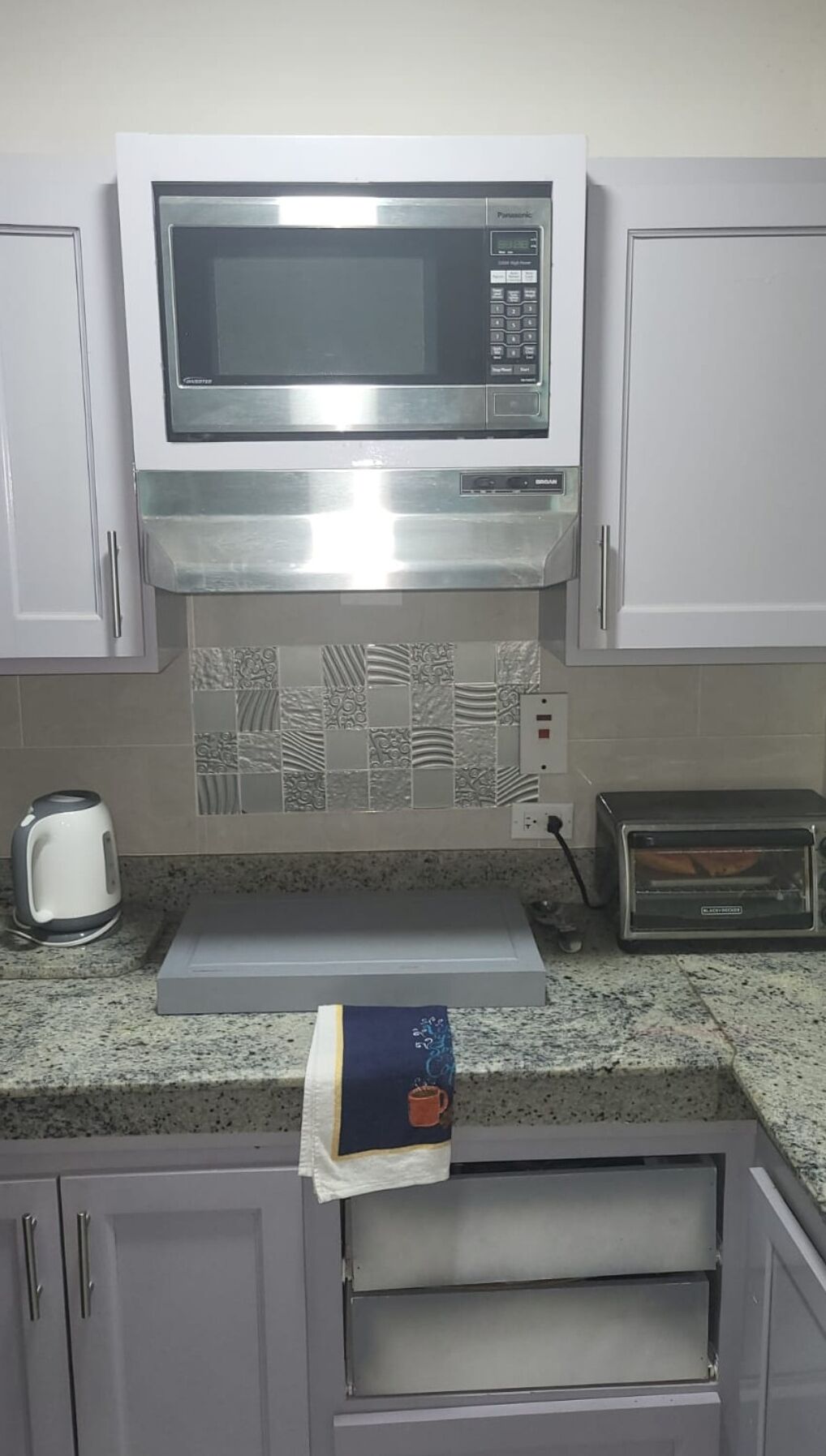 A kitchen with a microwave, toaster, and kettle.