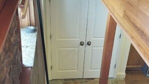 A wooden staircase leading to a white door with a stone floor. - Location, Location! Downtown Luxury 1 Bedroom Apt (Ann Arbor)