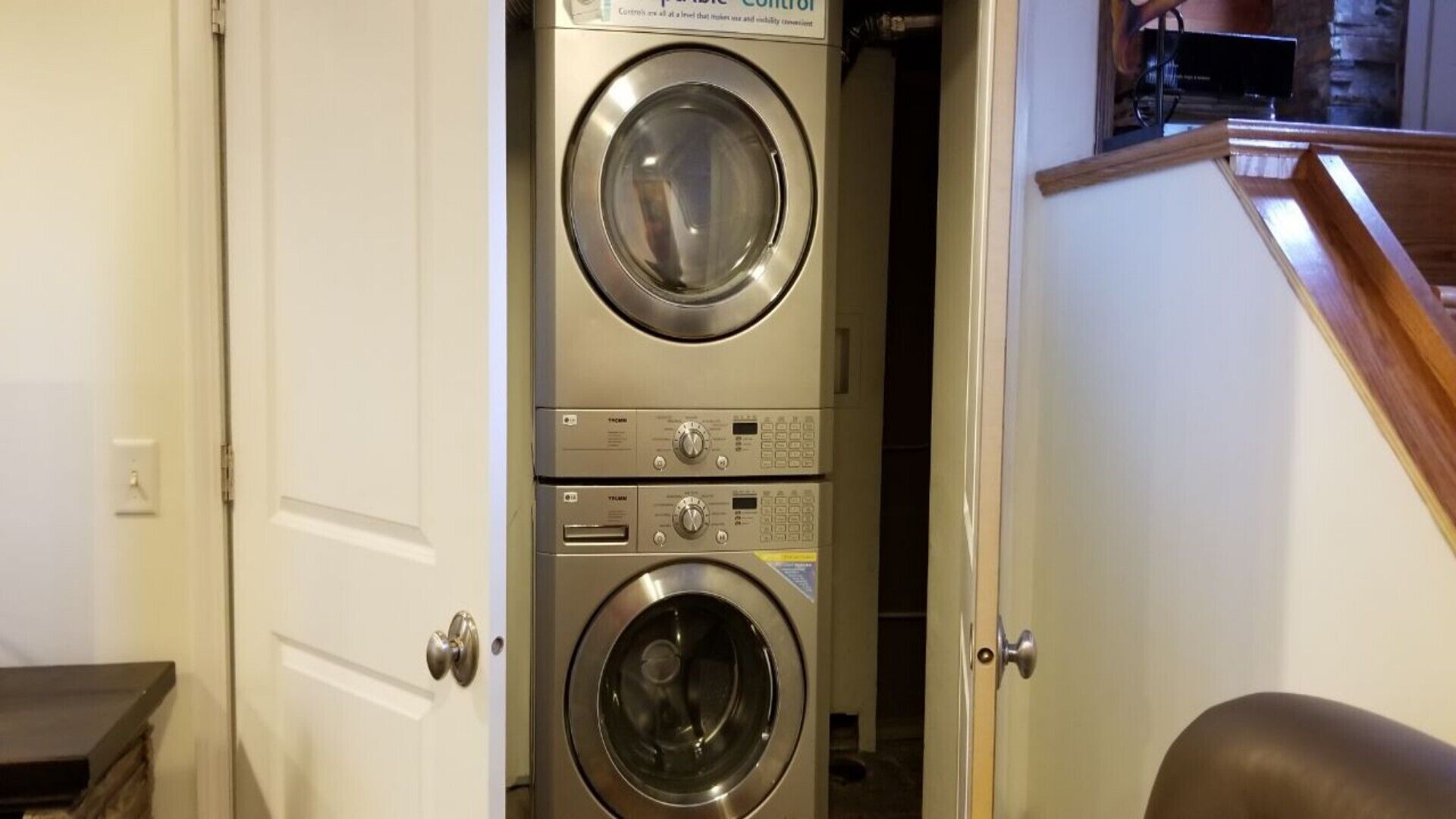A laundry room with two stacked front-loading washing machines and a dryer.