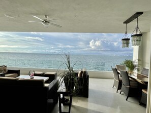 Relax in a spacious room with a comfortable seating area, dining table, and stunning ocean views.