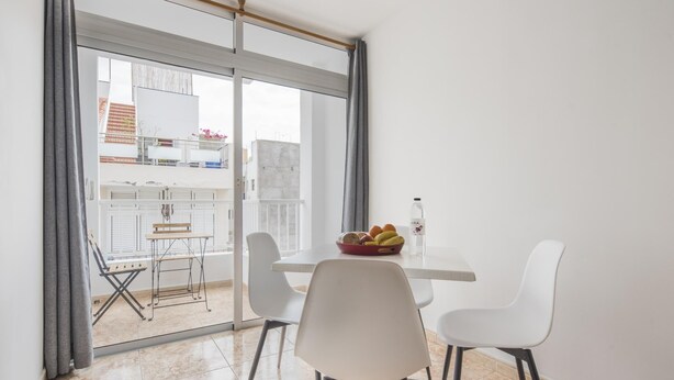 A dining area with a table and chairs, a bottle of water, and a bowl of fruit. - Nice apartment one minute from the beach (Playa de San Juan)