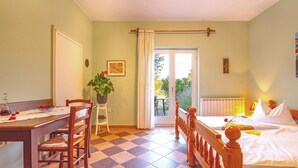 A room with a bed, a dining table with chairs, a potted plant, and a view of the outdoors. - Leandra in Rovinjsko Selo - Istrien / Leandra in Rovinjsko Selo - Appartement für 2 Personen ST1 (Rovinj)