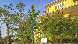 A yellow villa with a garden, a stone bench, and a chair with a cushion. - Leandra in Rovinjsko Selo - Istrien / Leandra in Rovinjsko Selo - Appartement für 2 Personen ST1 (Rovinj)