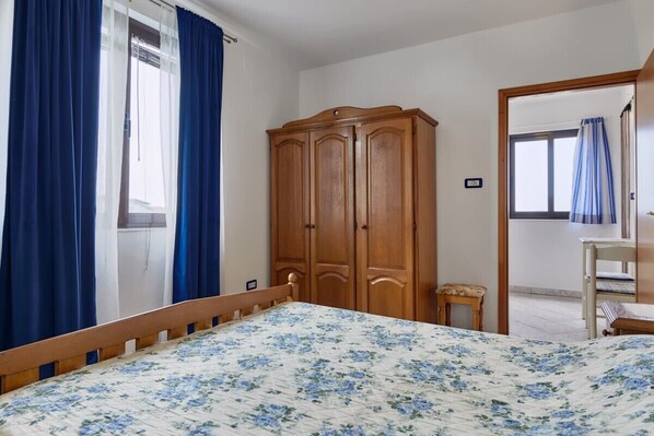 Una camera da letto con un letto, un'armadio in legno e un tavolino.