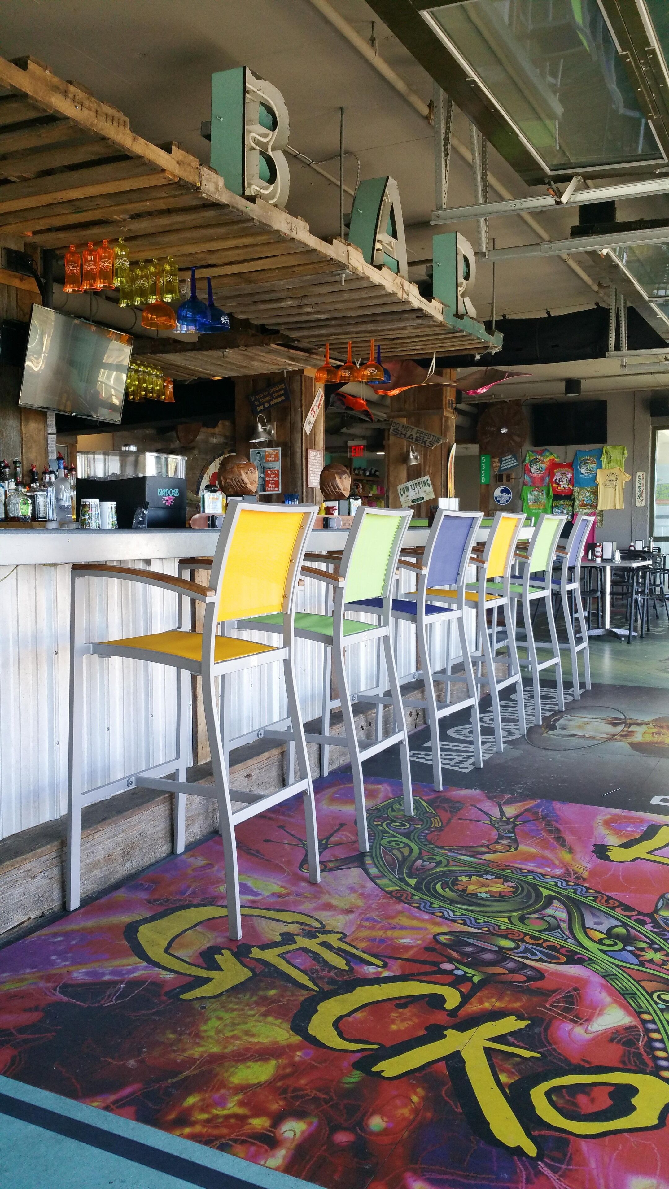A bar area with a counter, chairs, and a colorful floor design.