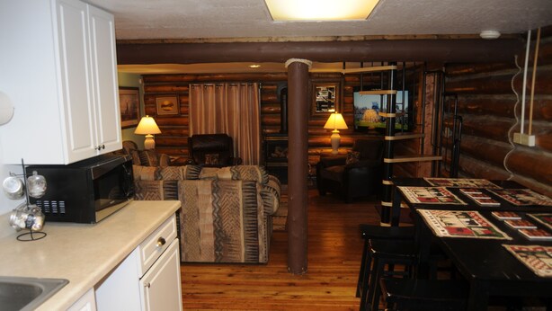 Ein Blockhaus-Interieur mit Küche, Essbereich und Wohnzimmer.
