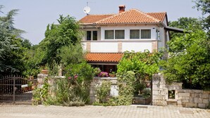 A two-story house with a tiled roof, surrounded by greenery and a stone wall. - Klara in Poreč - Istrien / Klara in Poreč - Appartement für 2 Personen AP2 (Porec)