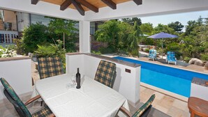 An outdoor patio with a pool, a table with chairs, and a view of the surrounding greenery. - Klara in Poreč - Istrien / Klara in Poreč - Appartement für 2 Personen AP2 (Porec)
