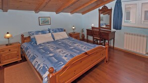 A bedroom with a wooden bed, nightstands, a dresser, a mirror, and a radiator. - Klara in Poreč - Istrien / Klara in Poreč - Appartement für 2 Personen AP2 (Porec)