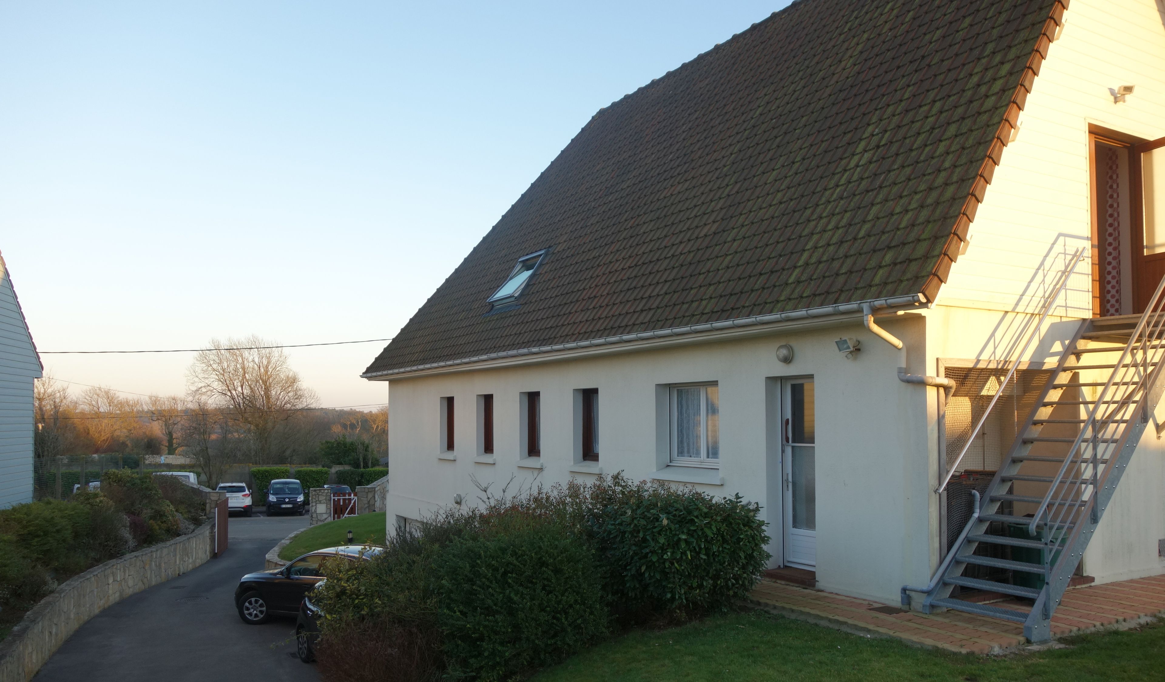 Une maison à deux étages, dotée d’un toit en pente, d’une porte d’entrée et d’un escalier menant à l’étage supérieur.