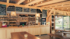 A cozy restaurant interior with wooden beams, a bar area with various bottles, and chalkboard menus. - Wooden hut 'Forest bed' near to the river Savinja (Mozirje)