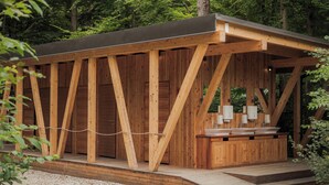 A wooden structure with a covered outdoor area, including a sink and a bench. - Wooden hut 'Forest bed' near to the river Savinja (Mozirje)