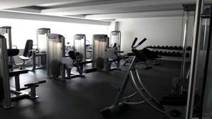 A gym with various exercise equipment, including weight machines and free weights. - CASTLEROCK SUITES AND CONDOS IN MEXICO CITY (México D.F.)