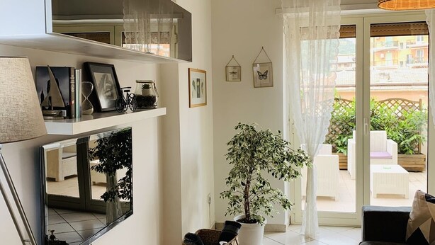 A living room with a sofa, a coffee table, a potted plant, and a large mirror. - NEW BEAUTIFUL APARTMENT WITH LARGE TERRACE- A CASA DI CAROLINA (Cassino)