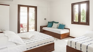 A bedroom with two beds, a window, and a door. - Luxurious Mani Peninsula Traditional Tower (East Mani)