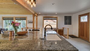 A kitchen with granite countertops, a stainless steel sink, and wooden beams. - Peshastin River Place-Riverfront near Leavenworth (Peshastin)