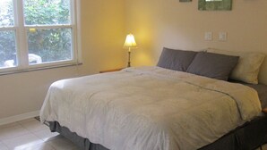 Ein Schlafzimmer mit Bett, Deckenventilator, Fenster und Lampe.