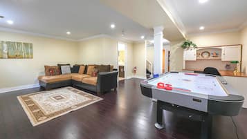 Relax in this spacious living room with a sofa and pool table.