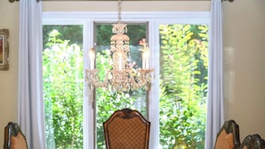 A dining area with a chandelier, a table, and chairs.
