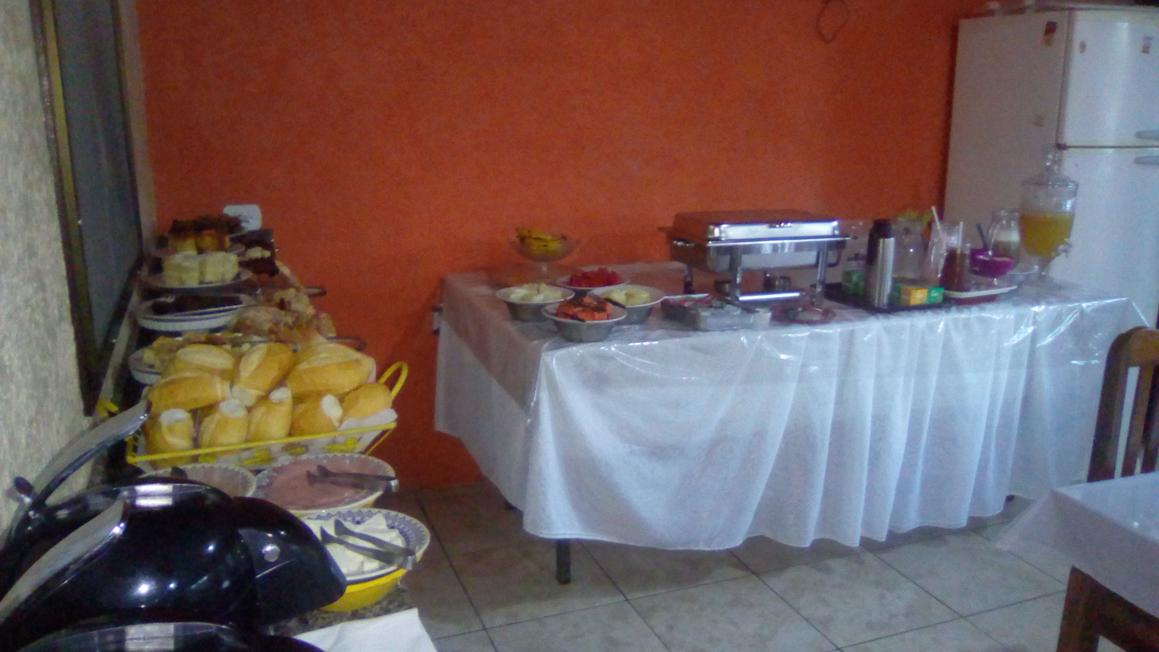 A buffet table with various food items and a refrigerator in the background.