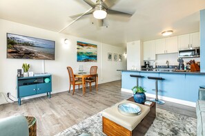 Una cucina moderna con una parete blu a contrasto, un tavolo da pranzo in legno e sgabelli da bar.