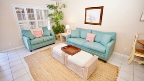 Relax in this stylish living room with two sofas, a side table, and a wicker coffee table.