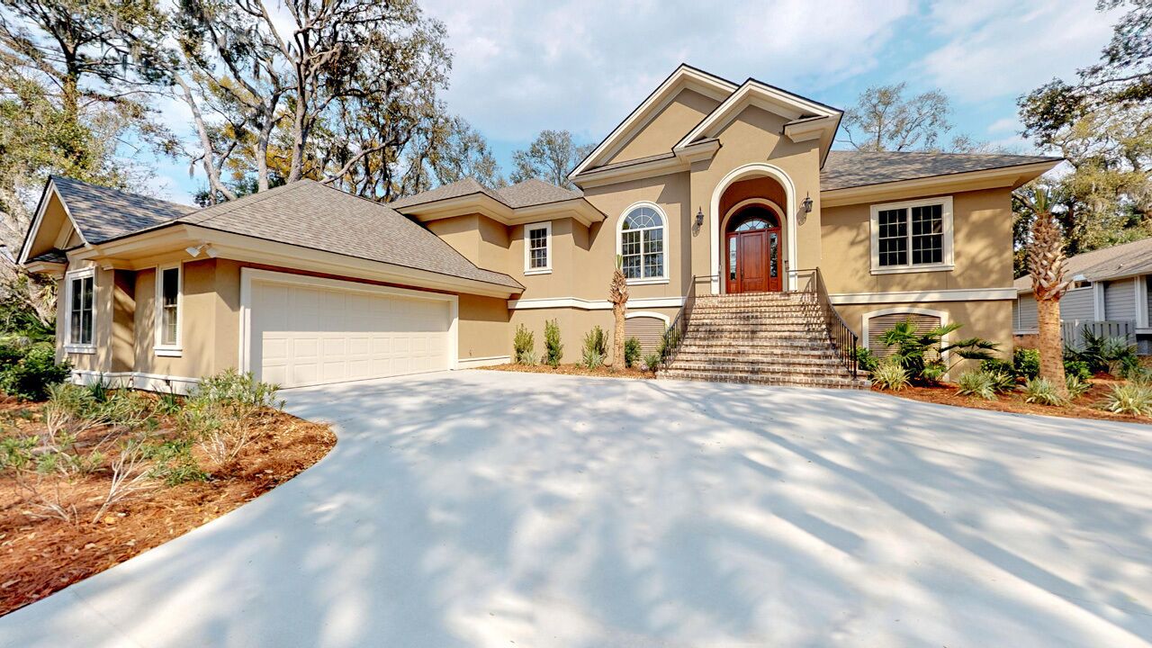 A two-story house with a garage, a front entrance with steps, and a driveway.