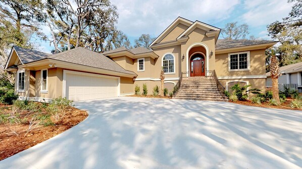 A two-story house with a garage, a front entrance with steps, and a driveway.