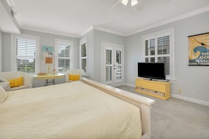 Relax in this serene bedroom with a large bed, TV, and a cozy reading nook.