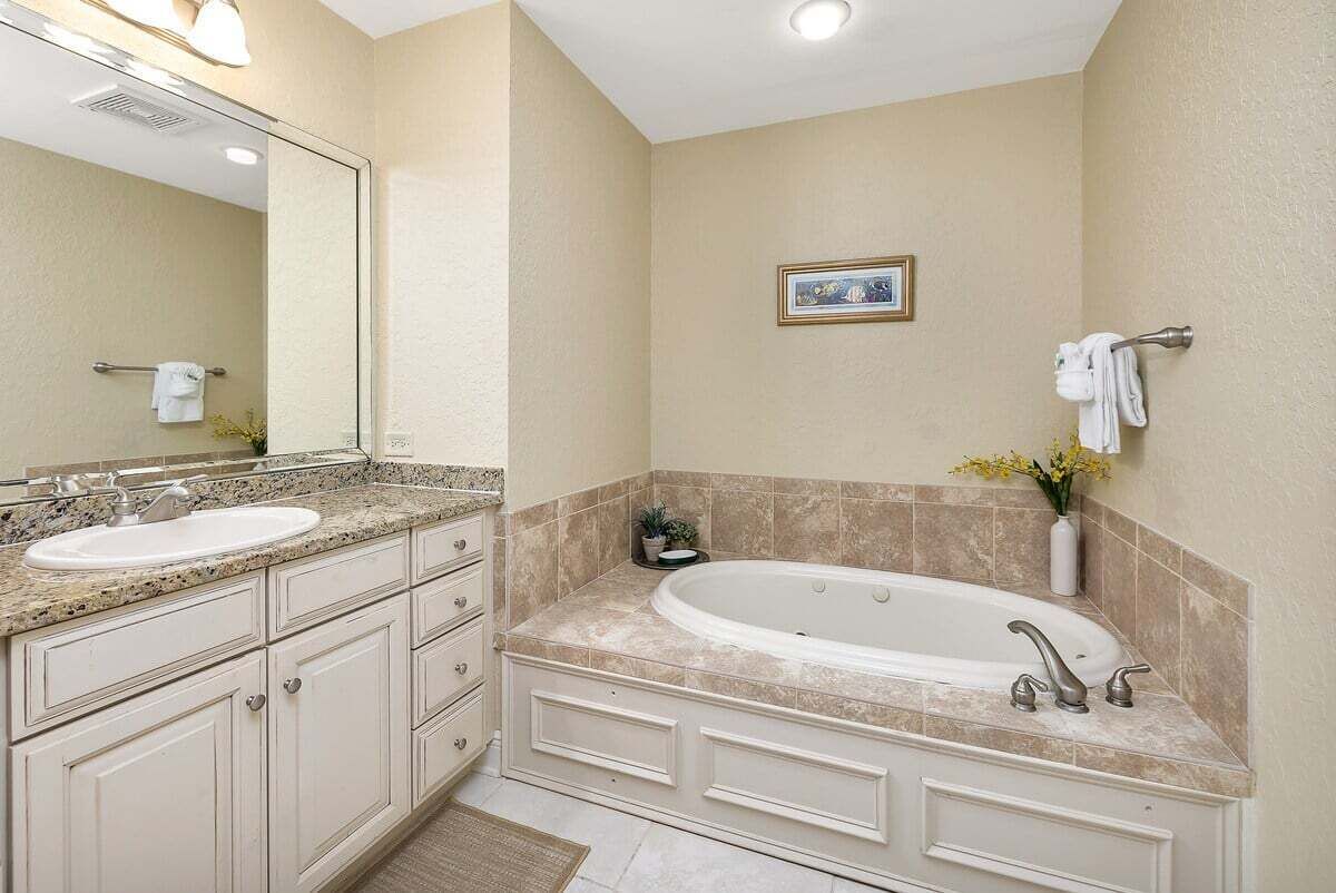Une salle de bain avec deux lavabos, une grande baignoire et un miroir.