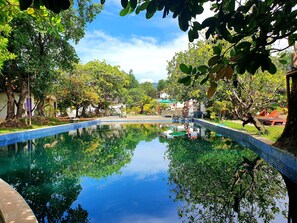 Una piscina al aire libre, sombrillas, sillones reclinables de piscina
