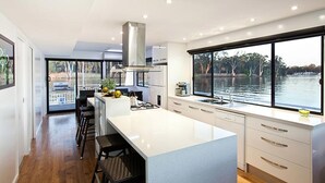 Una cucina moderna con una grande isola, un piano cottura a gas e vista su un lago.