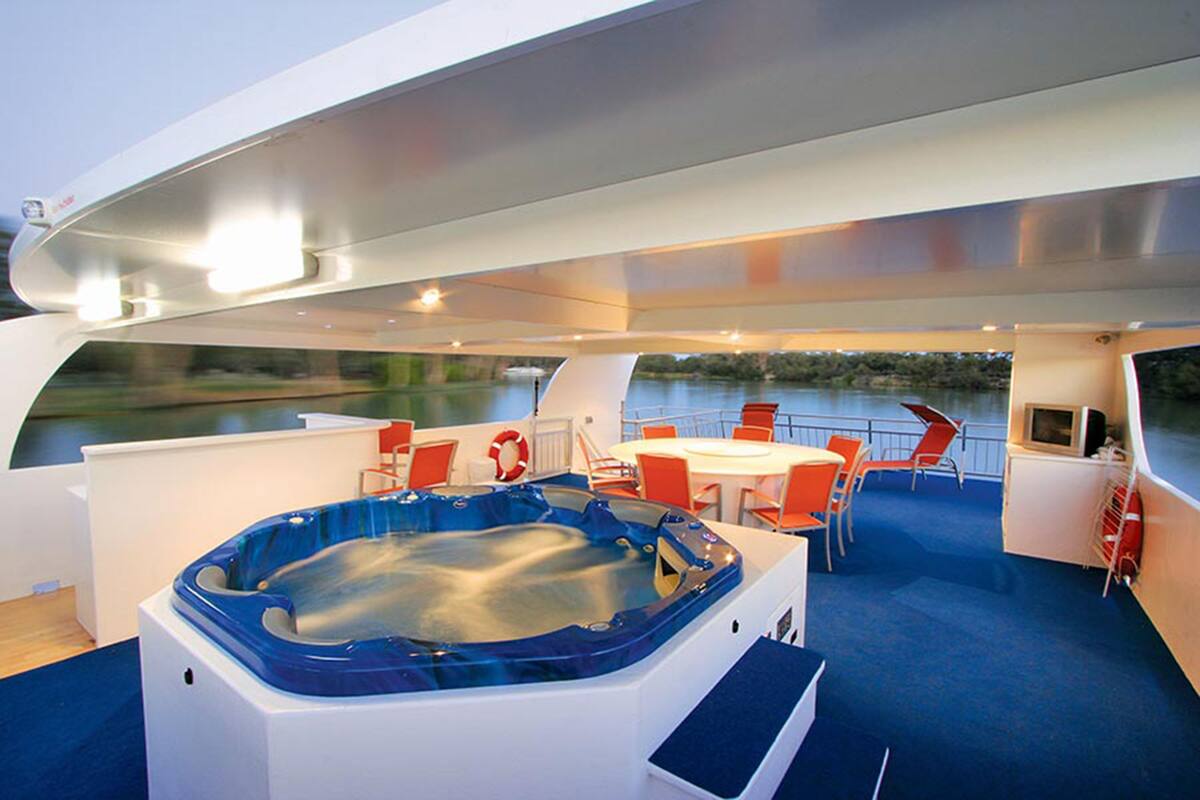 Un intérieur de bateau moderne comprenant un jacuzzi, un coin salon et un téléviseur.