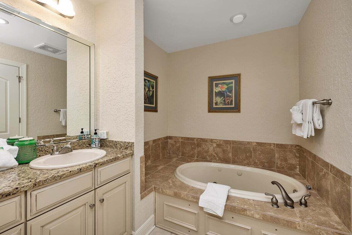 A bathroom with a sink, vanity, and bathtub.