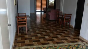 A spacious living area with a patterned floor, a ceiling fan, and a view through a door to a balcony. - Lasa Residence (Oranjestad)