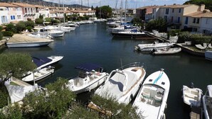 Un port de plaisance où sont amarrés des bateaux, entouré de bâtiments résidentiels.