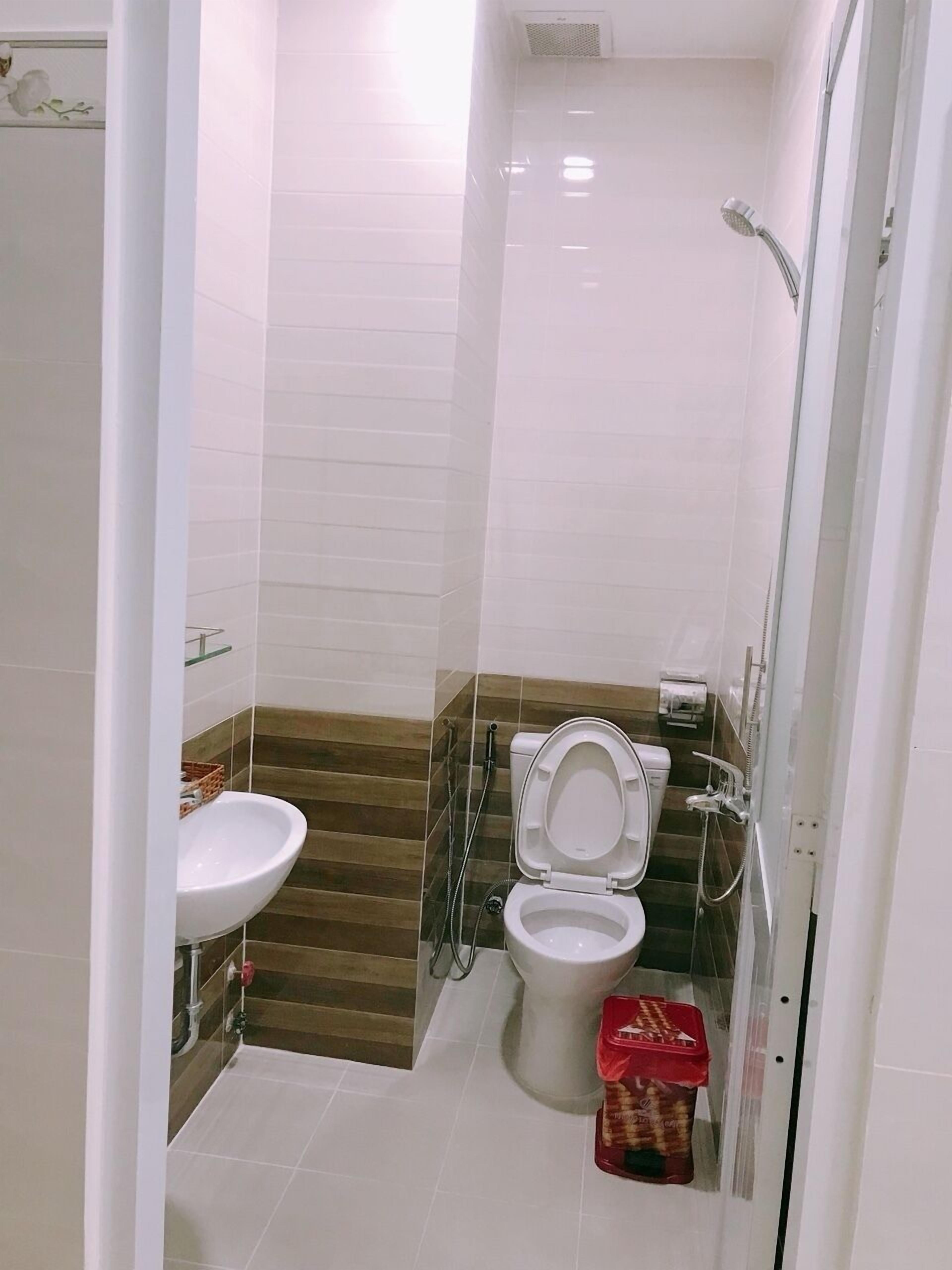 A bathroom with a toilet, sink, and shower.