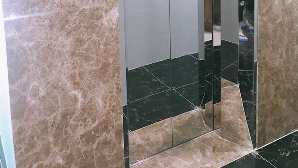 An elevator with a digital display, marble walls, and a tiled floor. - Thanh Vinh Hotel (Ho Chi Minh City)