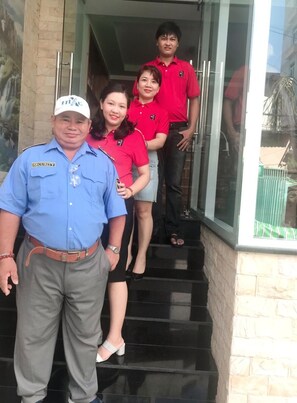 A group of people standing on a staircase outside a building with a glass door. - Thanh Vinh Hotel (Ho Chi Minh City)