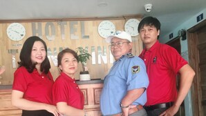 A reception area with wooden paneling, a clock, and a sign that reads "HOTEL". - Thanh Vinh Hotel (Ho Chi Minh City)