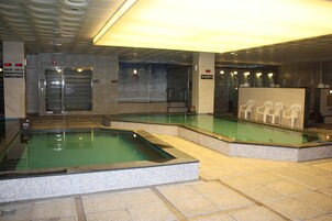 Ein Poolbereich mit mehreren Pools, einer Rezeption und einer Sitzgelegenheit.