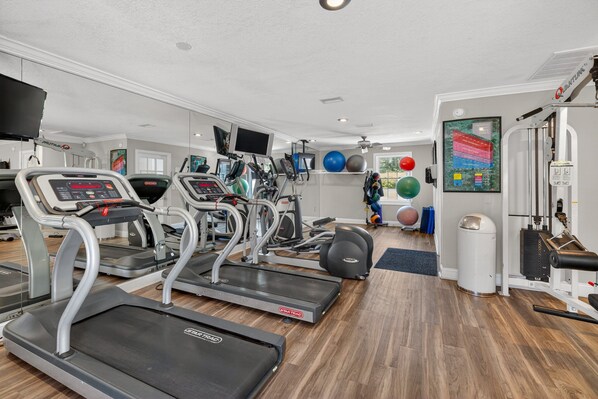 A gym with treadmills, elliptical machines, and various exercise equipment. - Oceanfront and Great Amenities! (Saint Simons Island)