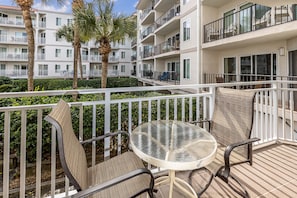 Enjoy a peaceful retreat on this balcony with a round table and two comfortable chairs.