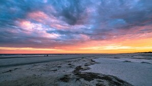 A beach with a wide sandy area and a clear sky. - Oceanview unit at The Beach Club.  Pool, Great Bea (Saint Simons Island)