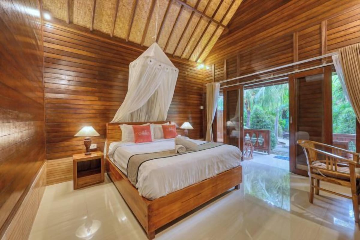 A wooden room with a bed, bedside lamps, and a canopy.