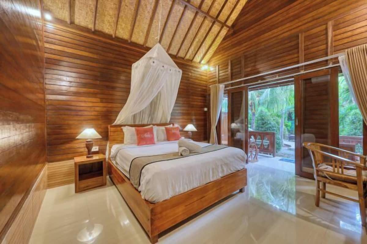 A wooden room with a bed, bedside lamps, and a canopy.