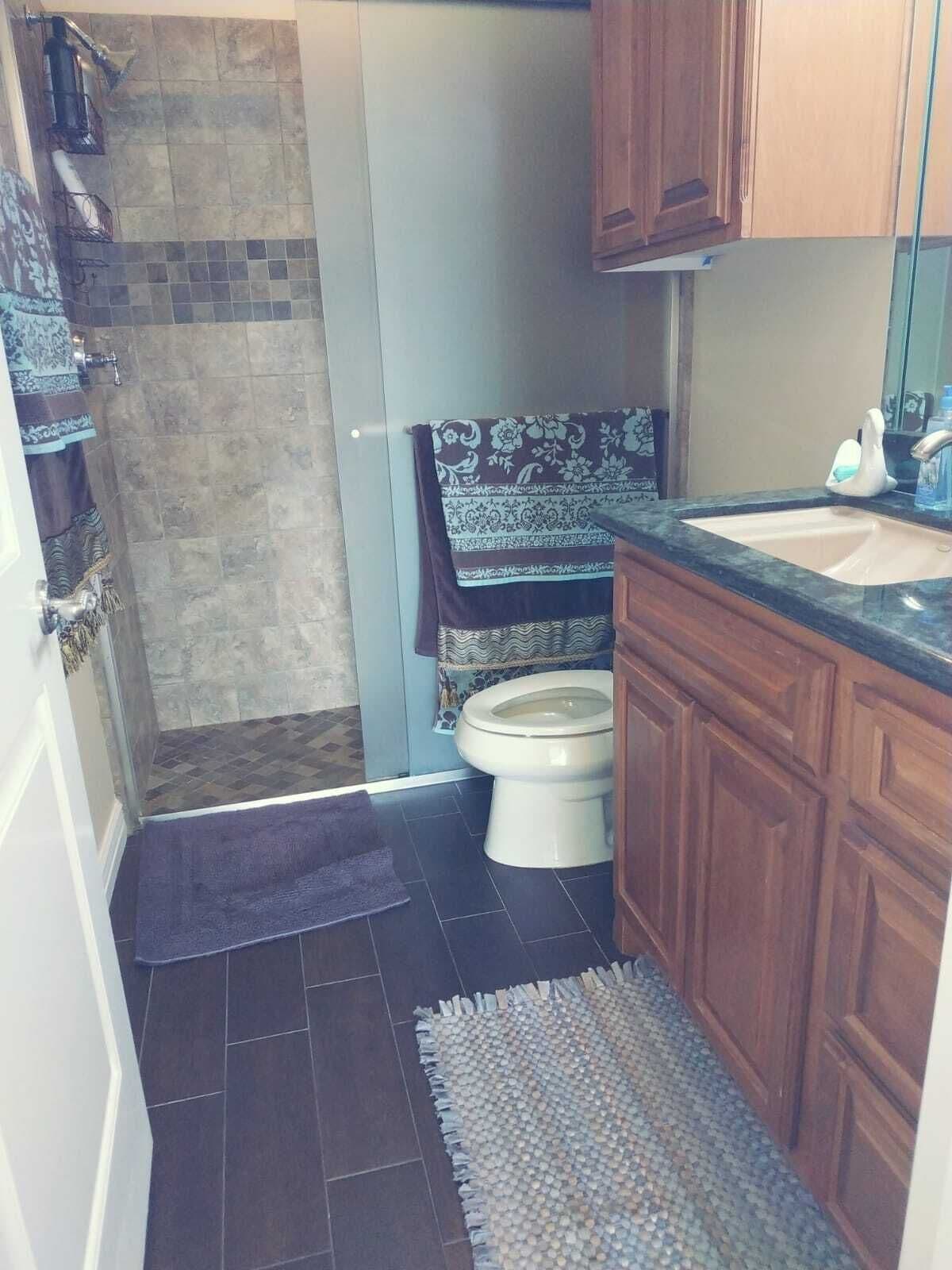 A compact bathroom with a shower, toilet, and sink.